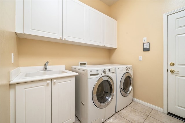 clothes washing area with cabinets, light tile patterned flooring, separate washer and dryer, and sink