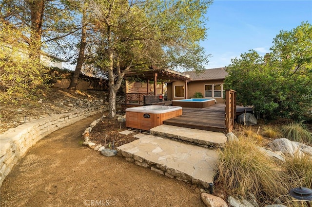 back of property with a wooden deck and a hot tub