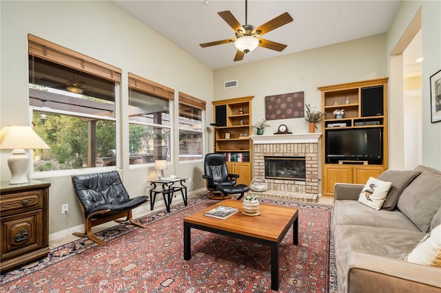 living room with a brick fireplace and ceiling fan