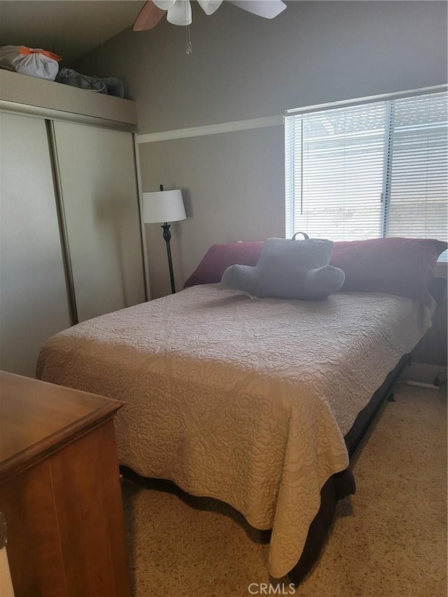 bedroom with lofted ceiling, ceiling fan, and a closet