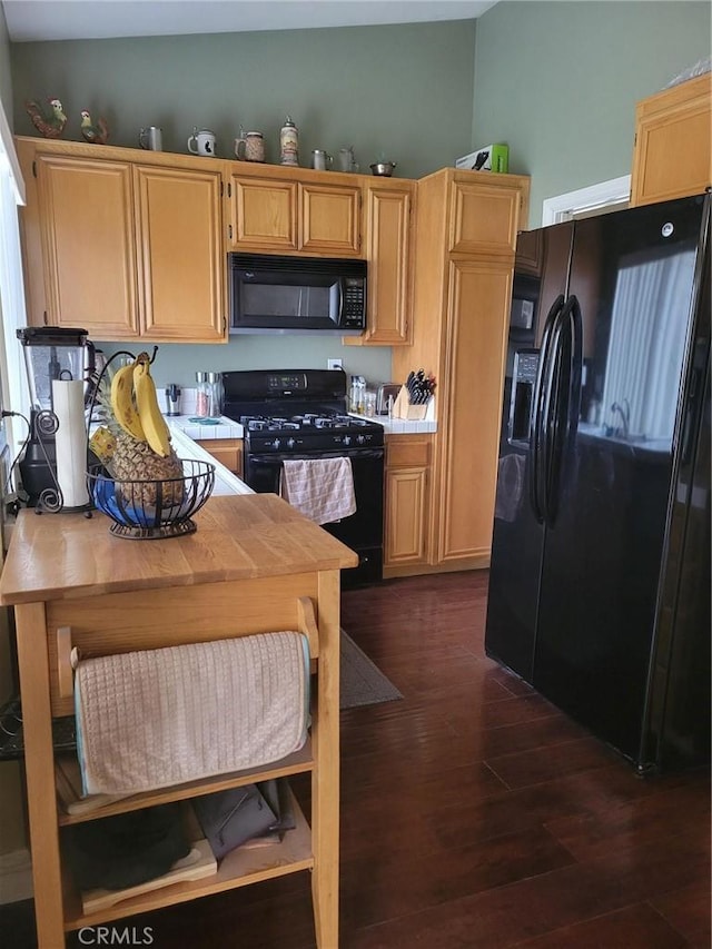 kitchen with dark hardwood / wood-style floors, light brown cabinets, and black appliances