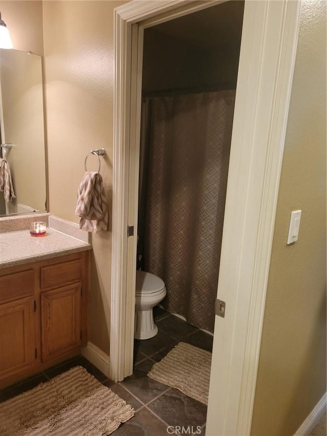 bathroom featuring vanity, tile patterned floors, and toilet