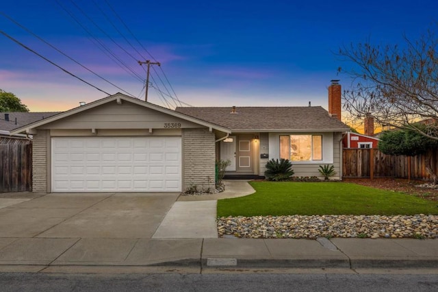 ranch-style house with a garage and a lawn