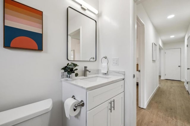 bathroom featuring vanity, hardwood / wood-style floors, and toilet