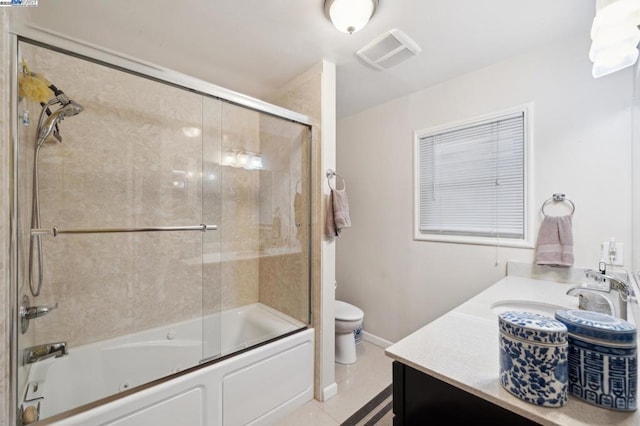 full bathroom featuring enclosed tub / shower combo, vanity, toilet, and tile patterned flooring