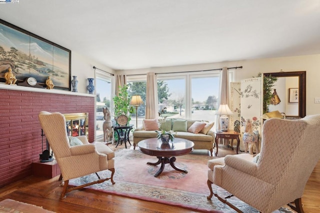 living room with hardwood / wood-style floors and a brick fireplace