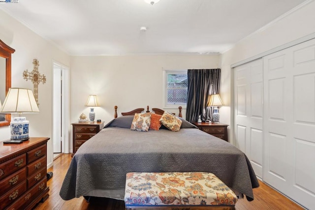 bedroom featuring crown molding, light hardwood / wood-style floors, and a closet