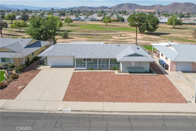 single story home with a mountain view, a garage, and covered porch