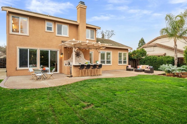 back of house featuring a bar, outdoor lounge area, a patio area, and a lawn