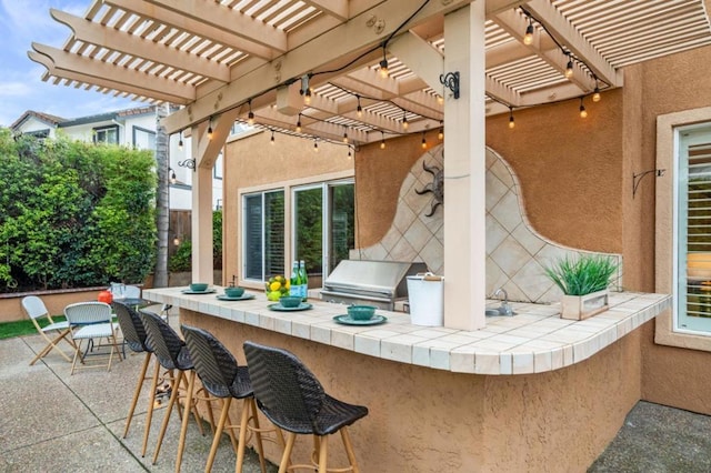 view of patio / terrace with a grill, exterior bar, and a pergola