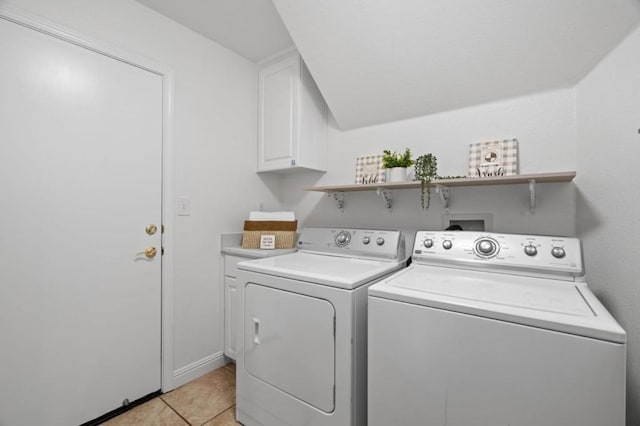 laundry area with cabinets, light tile patterned floors, and washer and dryer