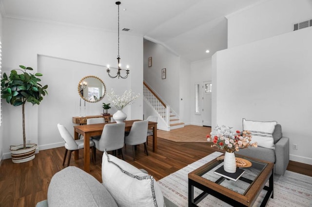 living room featuring hardwood / wood-style flooring, a chandelier, and vaulted ceiling