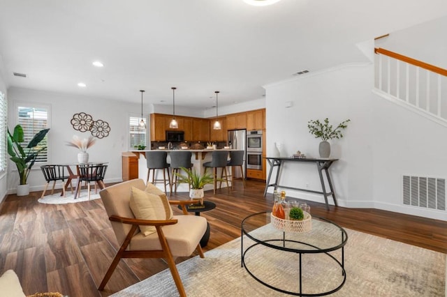 living room with a healthy amount of sunlight and dark hardwood / wood-style flooring