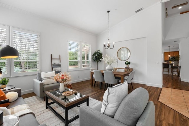 living room with wood-type flooring, a wealth of natural light, and a notable chandelier