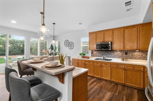 kitchen with gas stovetop, tasteful backsplash, decorative light fixtures, ornamental molding, and dark hardwood / wood-style floors