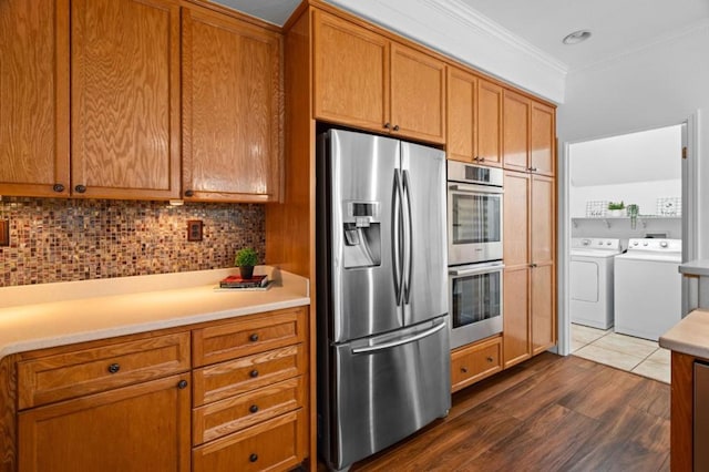 kitchen featuring stainless steel appliances, dark hardwood / wood-style floors, ornamental molding, separate washer and dryer, and decorative backsplash