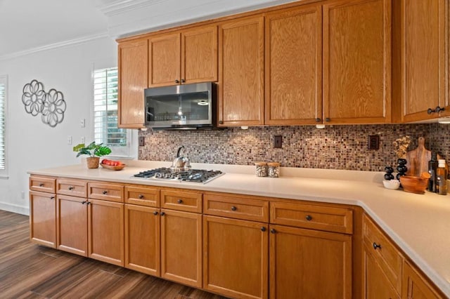 kitchen featuring stainless steel appliances, ornamental molding, dark hardwood / wood-style floors, and decorative backsplash