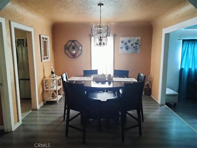 dining area featuring a notable chandelier, baseboards, dark wood-style flooring, and a textured ceiling