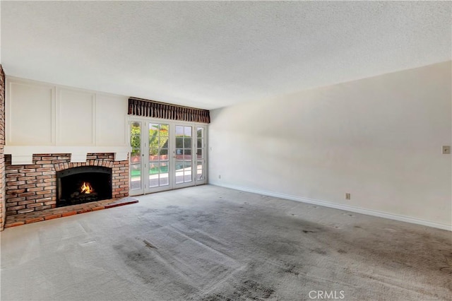 unfurnished living room featuring light carpet, a fireplace, and a textured ceiling