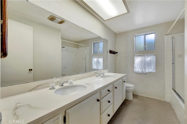 full bathroom featuring vanity, shower / bath combination with glass door, and toilet