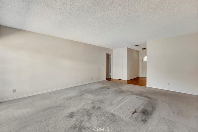 unfurnished room with a textured ceiling and carpet