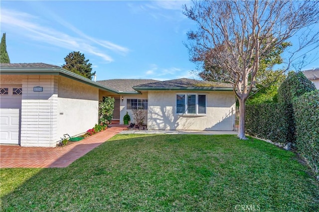 single story home with a garage and a front lawn