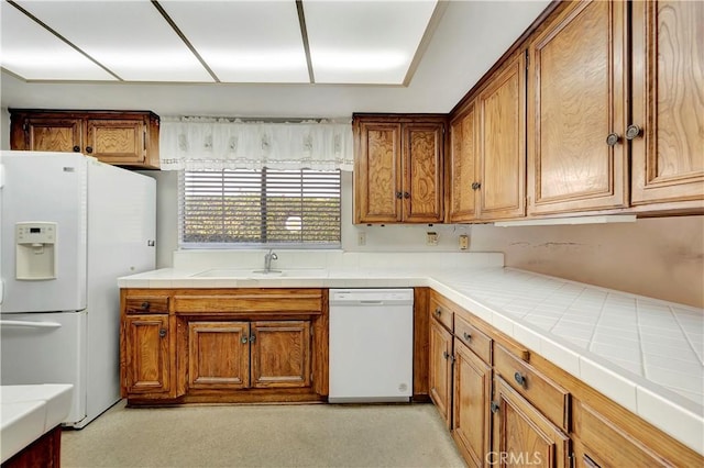 kitchen featuring sink, white appliances, and tile countertops