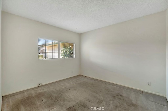 unfurnished room featuring light colored carpet and a textured ceiling