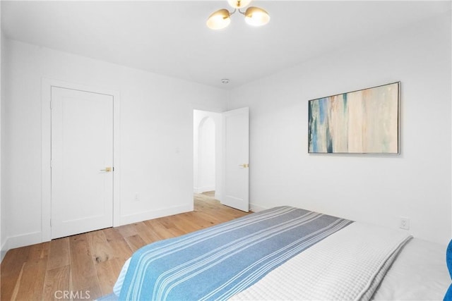 bedroom featuring hardwood / wood-style flooring and a notable chandelier