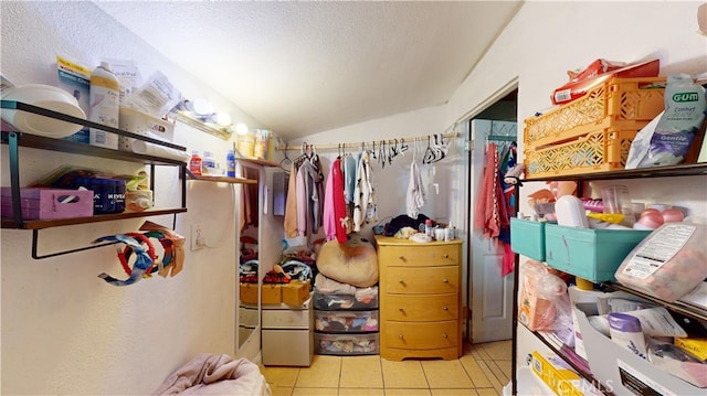 walk in closet featuring vaulted ceiling and light tile patterned floors