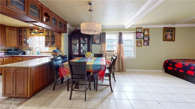 dining space with light tile patterned floors, beam ceiling, ornamental molding, and sink