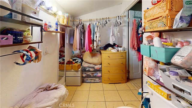 walk in closet with light tile patterned floors and vaulted ceiling