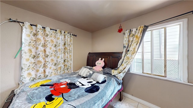 bedroom with multiple windows and light tile patterned floors