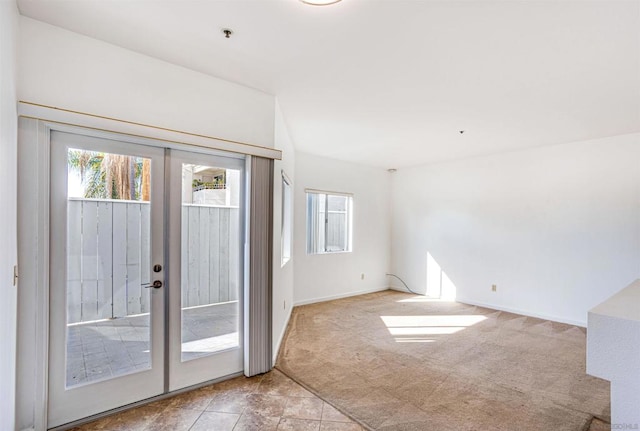 interior space with light carpet, a wealth of natural light, and french doors