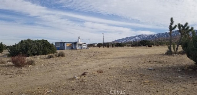 view of yard with a rural view and a mountain view
