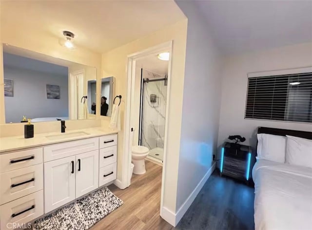 bathroom featuring vanity, wood-type flooring, toilet, and walk in shower