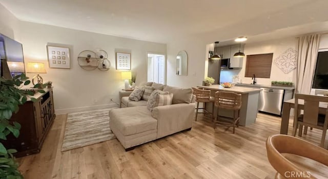 living room with sink and light wood-type flooring