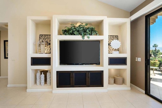 unfurnished living room featuring lofted ceiling, tile patterned flooring, and built in features