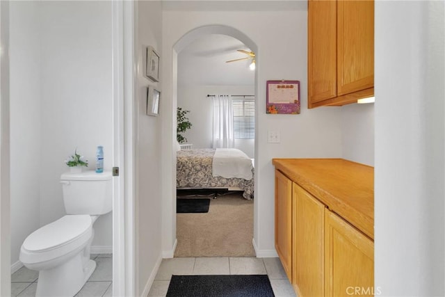 bathroom featuring ceiling fan, tile patterned floors, and toilet