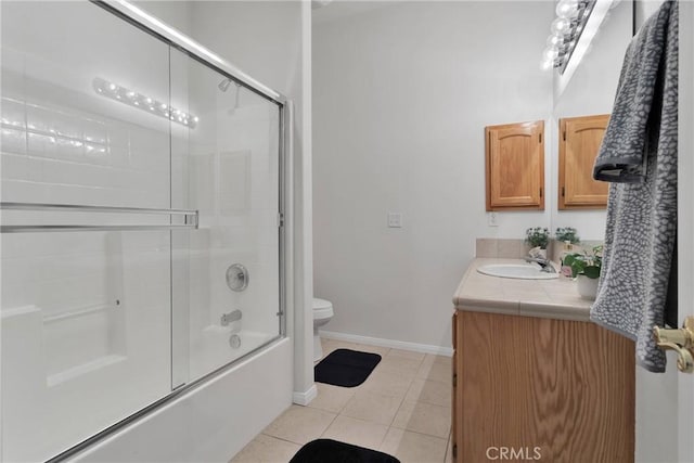 full bathroom with tile patterned flooring, vanity, shower / bath combination with glass door, and toilet