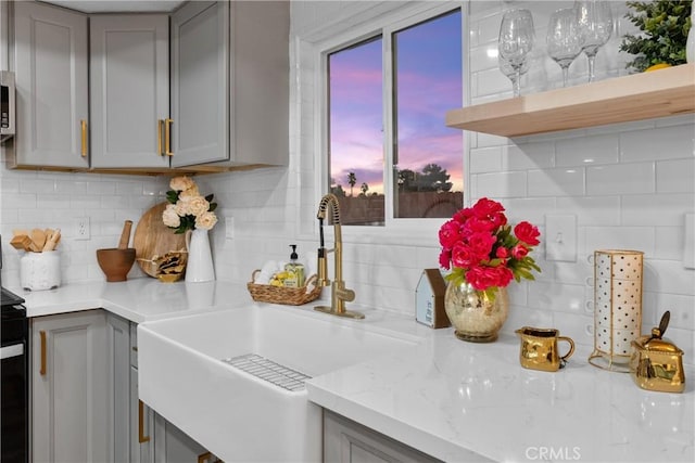 kitchen with gray cabinets, sink, and backsplash