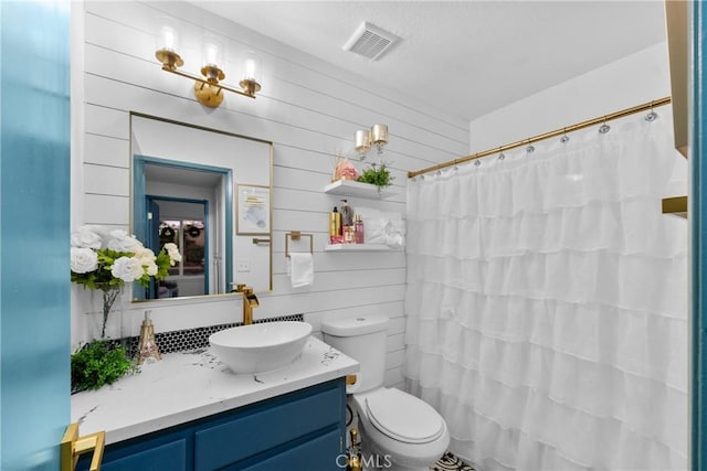 bathroom featuring walk in shower, vanity, and toilet