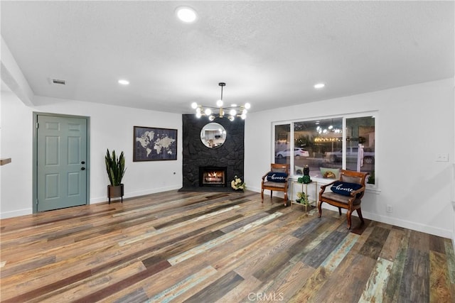 sitting room featuring hardwood / wood-style flooring, a high end fireplace, and an inviting chandelier