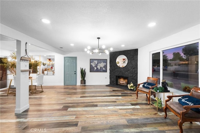 interior space featuring a high end fireplace, a chandelier, wood-type flooring, and a textured ceiling