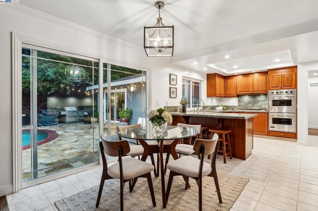 dining area featuring crown molding, a chandelier, and a tray ceiling