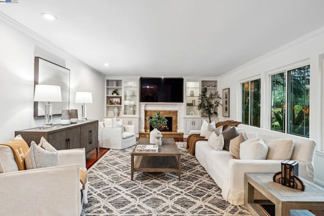 living room featuring ornamental molding, hardwood / wood-style floors, and built in features