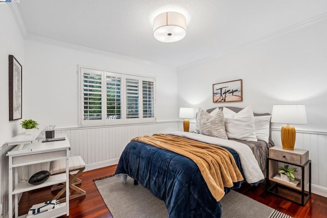 bedroom with ornamental molding and dark hardwood / wood-style flooring