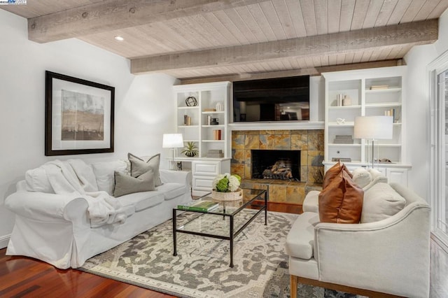 living room with a stone fireplace, hardwood / wood-style floors, beam ceiling, and wooden ceiling