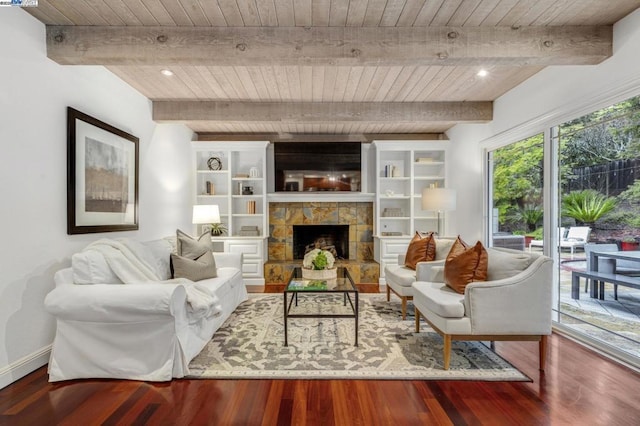 living room featuring beamed ceiling, a stone fireplace, hardwood / wood-style floors, and wooden ceiling