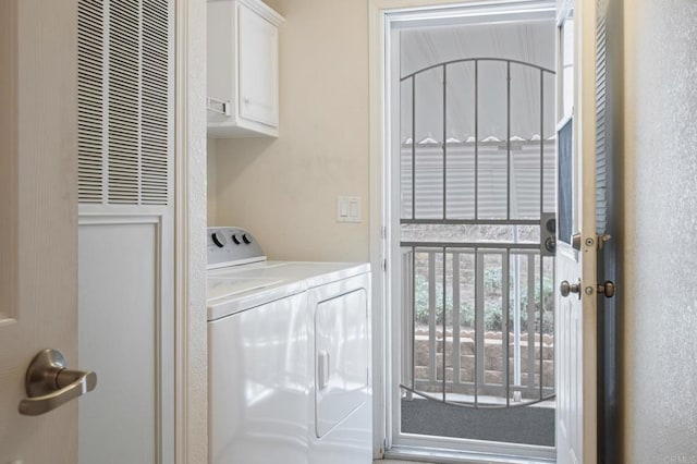 clothes washing area with cabinets and washer and clothes dryer